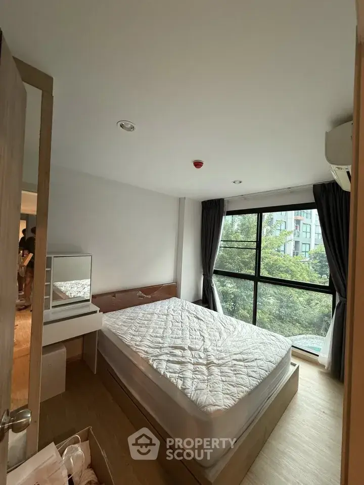 Cozy bedroom with large window and natural light in modern apartment