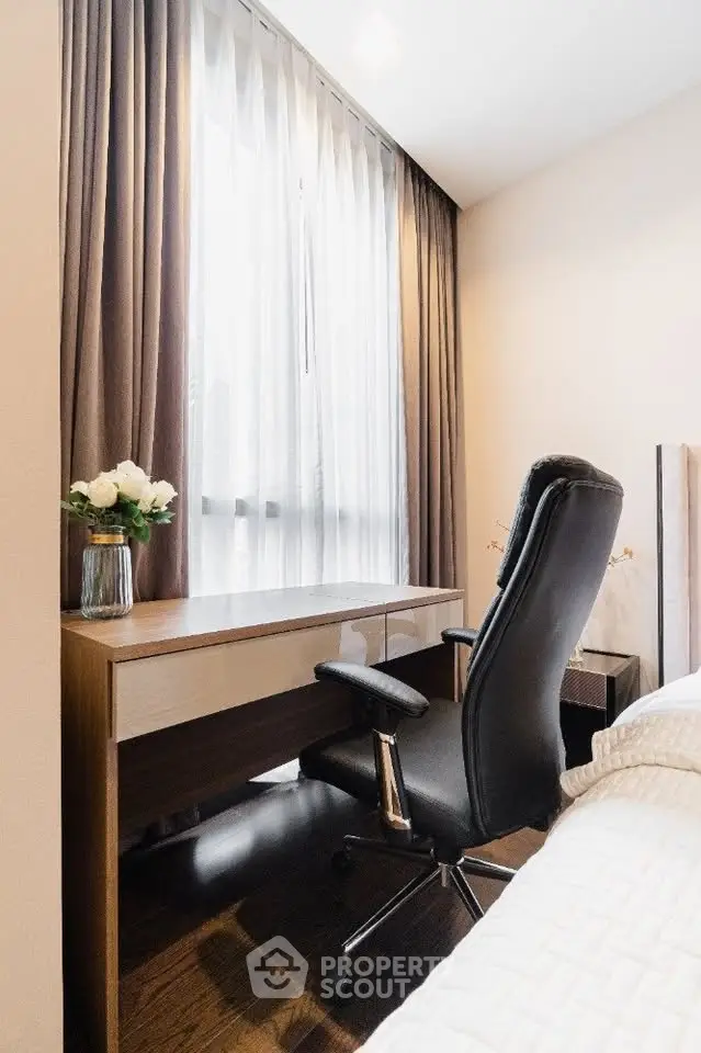Modern study area with sleek desk and ergonomic chair by a large window, perfect for productivity.