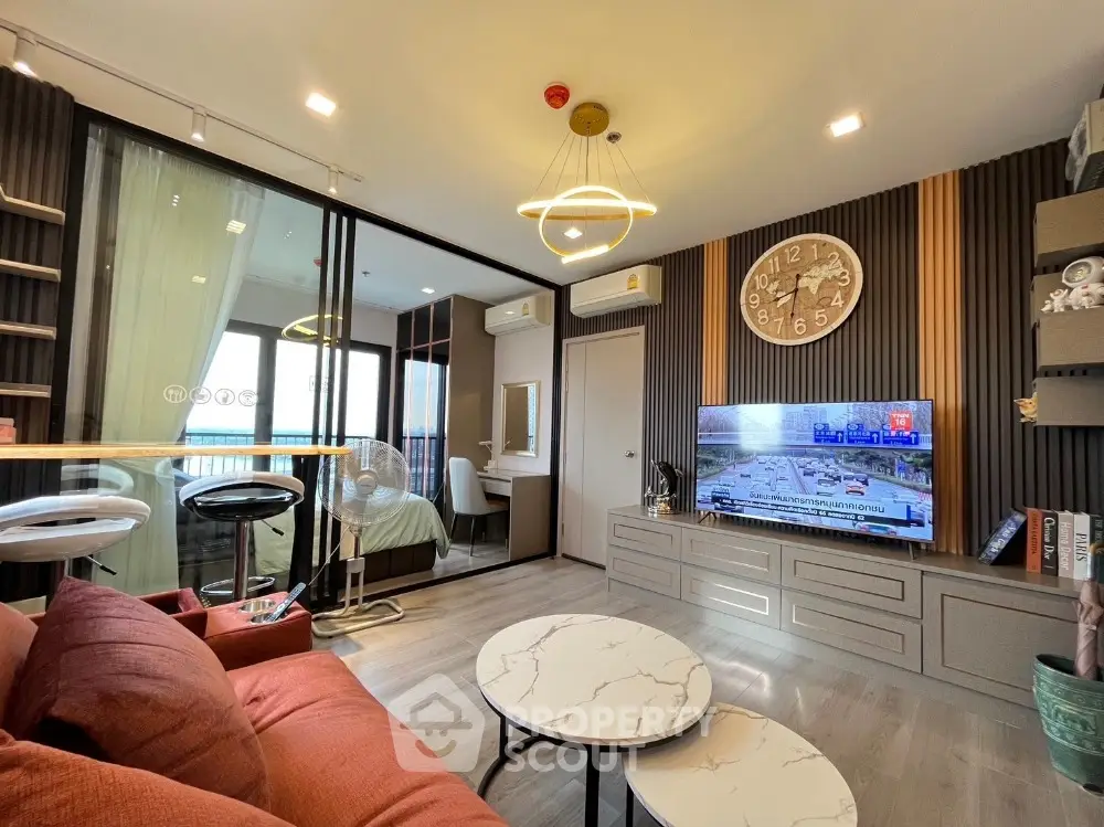 Modern living room with stylish decor and open layout leading to bedroom