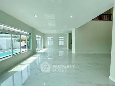 Spacious modern living room with large windows and pool view