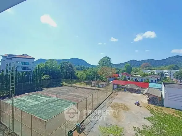 Scenic view of tennis court with mountain backdrop in residential area