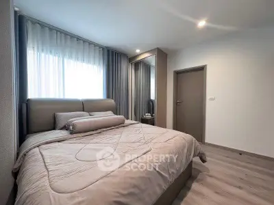 Modern bedroom with stylish decor and large window for natural light.