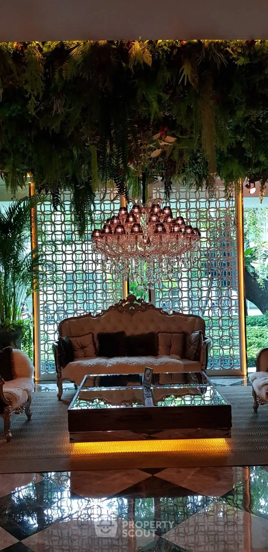 Luxurious living room with elegant chandelier and lush greenery view, perfect for sophisticated gatherings.