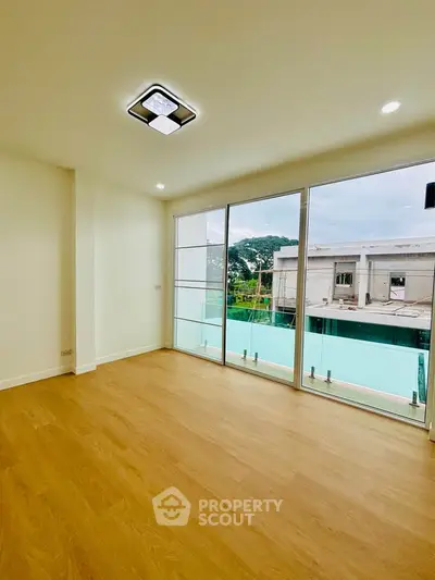 Spacious room with large windows offering a serene view, perfect for modern living.