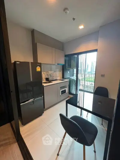 Modern kitchen with sleek appliances and city view from balcony.