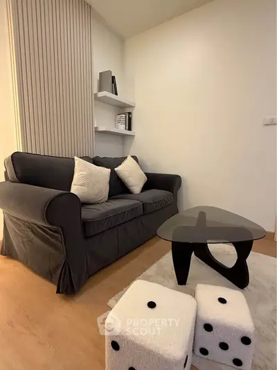 Cozy living room with modern sofa, unique coffee table, and playful dice stools.