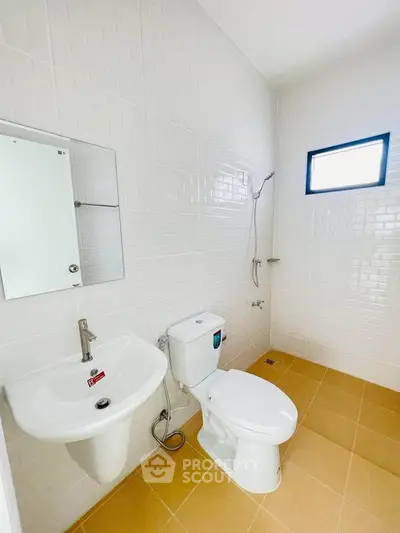 Modern bathroom with white tiles and sleek fixtures in a real estate property.