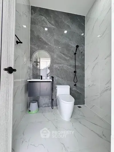 Modern bathroom with sleek design, featuring marble tiles and contemporary fixtures.