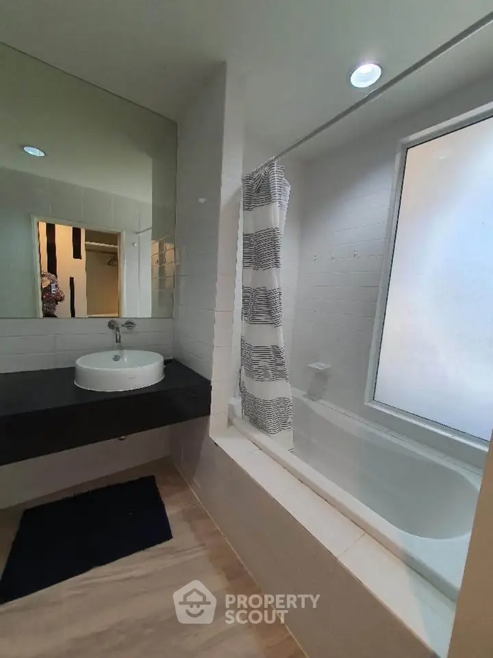 Modern bathroom with bathtub and sleek black countertop