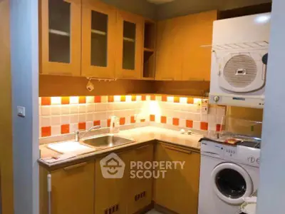 Cozy kitchen with wooden cabinets, washing machine, and vibrant backsplash tiles.