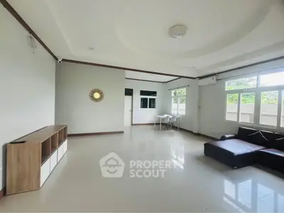 Spacious living room with modern decor and large windows offering natural light.