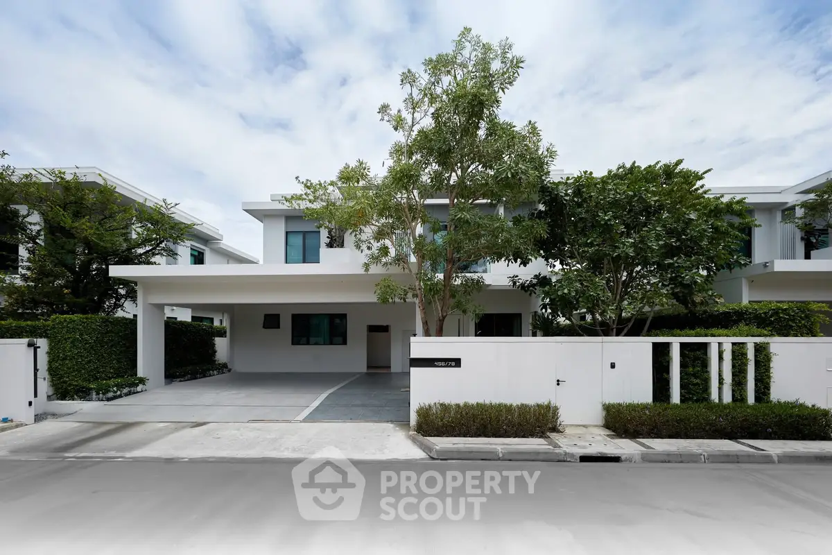 Modern two-story house with sleek design and lush greenery