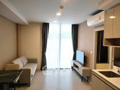 Modern living room with sleek furniture and natural light from large window.