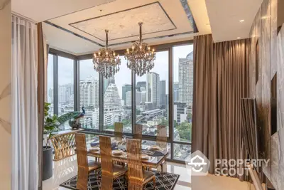 Luxurious dining area with stunning city view and elegant chandeliers in modern high-rise apartment.