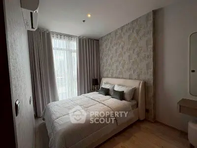 Cozy modern bedroom with stylish decor and large window for natural light.