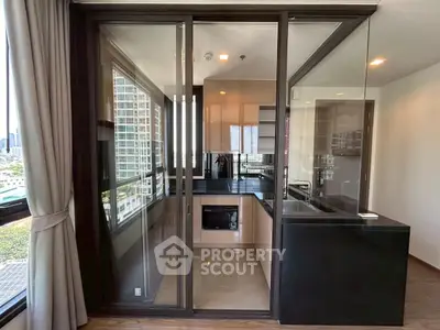 Modern kitchen with sleek glass doors and city view, featuring built-in appliances and stylish cabinetry.