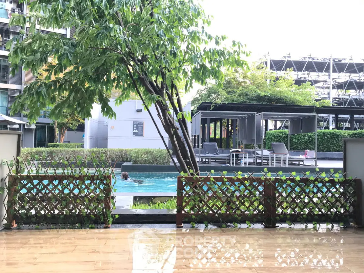 Luxurious poolside view with modern outdoor seating and lush greenery.