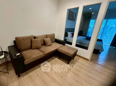 Modern living room with cozy sofa and view into stylish bedroom
