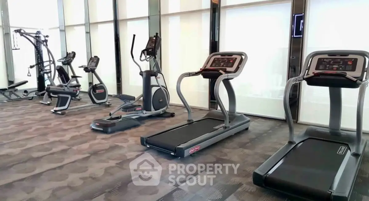 Modern gym with state-of-the-art fitness equipment in luxury residential building.