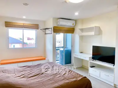 Modern bedroom with balcony, air conditioning, and TV in a cozy apartment.