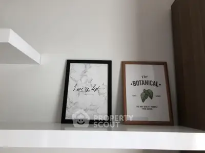 Modern shelf with decorative framed art in minimalist interior design.
