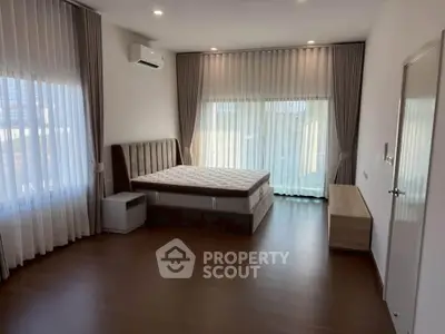 Spacious bedroom with large windows and modern furnishings