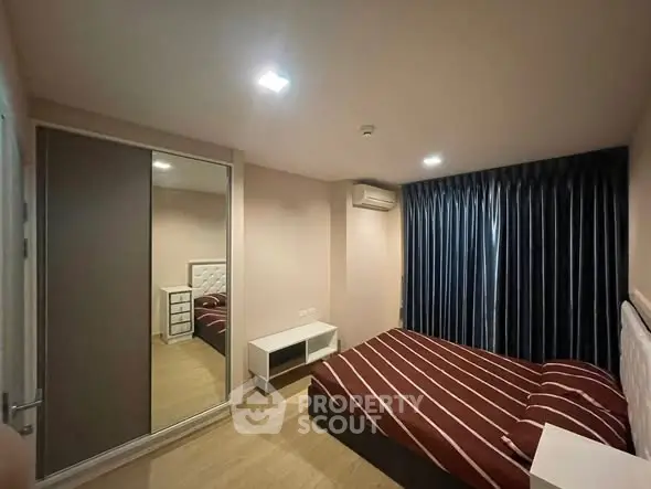 Modern bedroom with stylish decor and mirrored wardrobe in a cozy apartment.