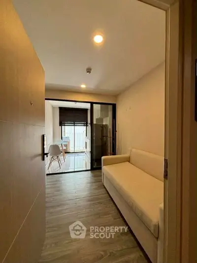 Modern apartment entrance with cozy sofa and dining area view