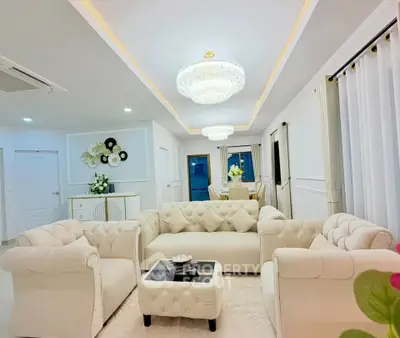 Luxurious living room with elegant white sofas and crystal chandeliers in a modern home.