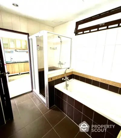 Spacious bathroom with modern bathtub and shower enclosure in a stylish home