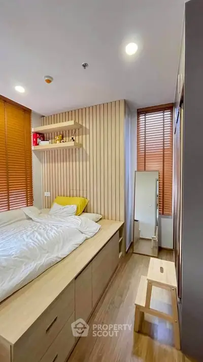 Modern bedroom with wooden accents and built-in storage, featuring cozy lighting and a minimalist design.