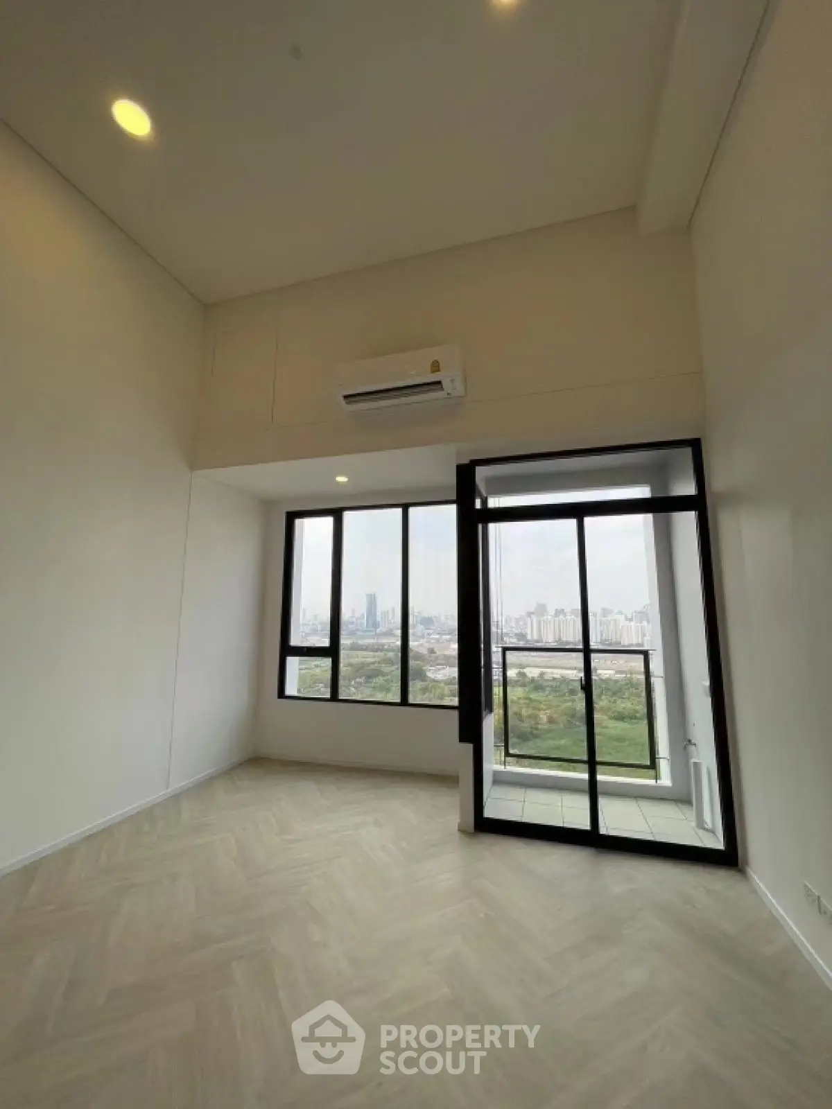 Spacious high-rise apartment with floor-to-ceiling windows and stunning city view.