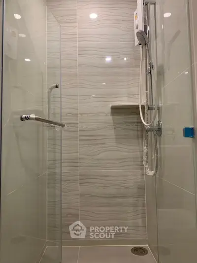 Modern shower with glass doors and sleek tile design in a contemporary bathroom.