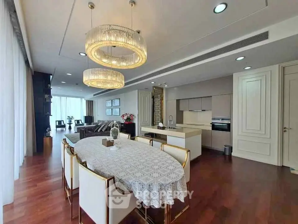 Luxurious open-plan living and dining area with elegant chandeliers and modern kitchen.