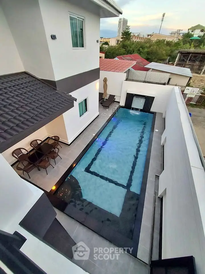 Luxurious modern home with private pool and stylish outdoor seating area, perfect for relaxation and entertainment.