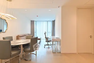 Modern living room with dining area and study desk, featuring elegant furniture and natural light.