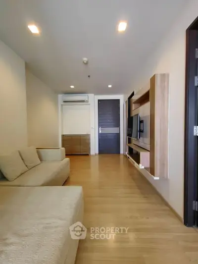 Modern living room with sleek wooden flooring and minimalist furniture