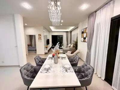 Luxurious open-plan living and dining area with elegant decor and modern lighting.