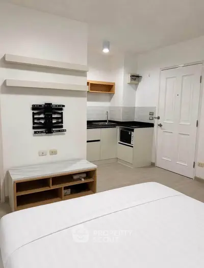 Modern studio apartment with compact kitchen and sleek interior design