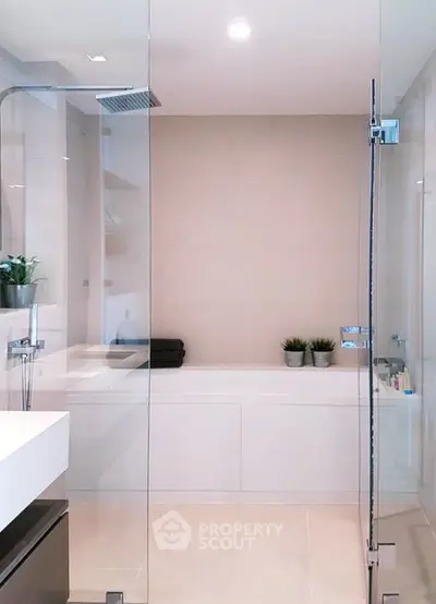 Modern bathroom with glass shower and sleek fixtures in a contemporary home.