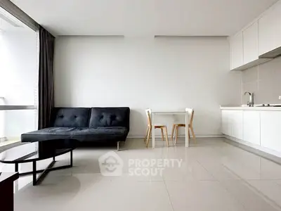 Modern minimalist living room with sleek kitchen and stylish furniture in open layout apartment.