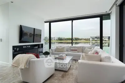 Luxurious living room with panoramic water views and modern decor.