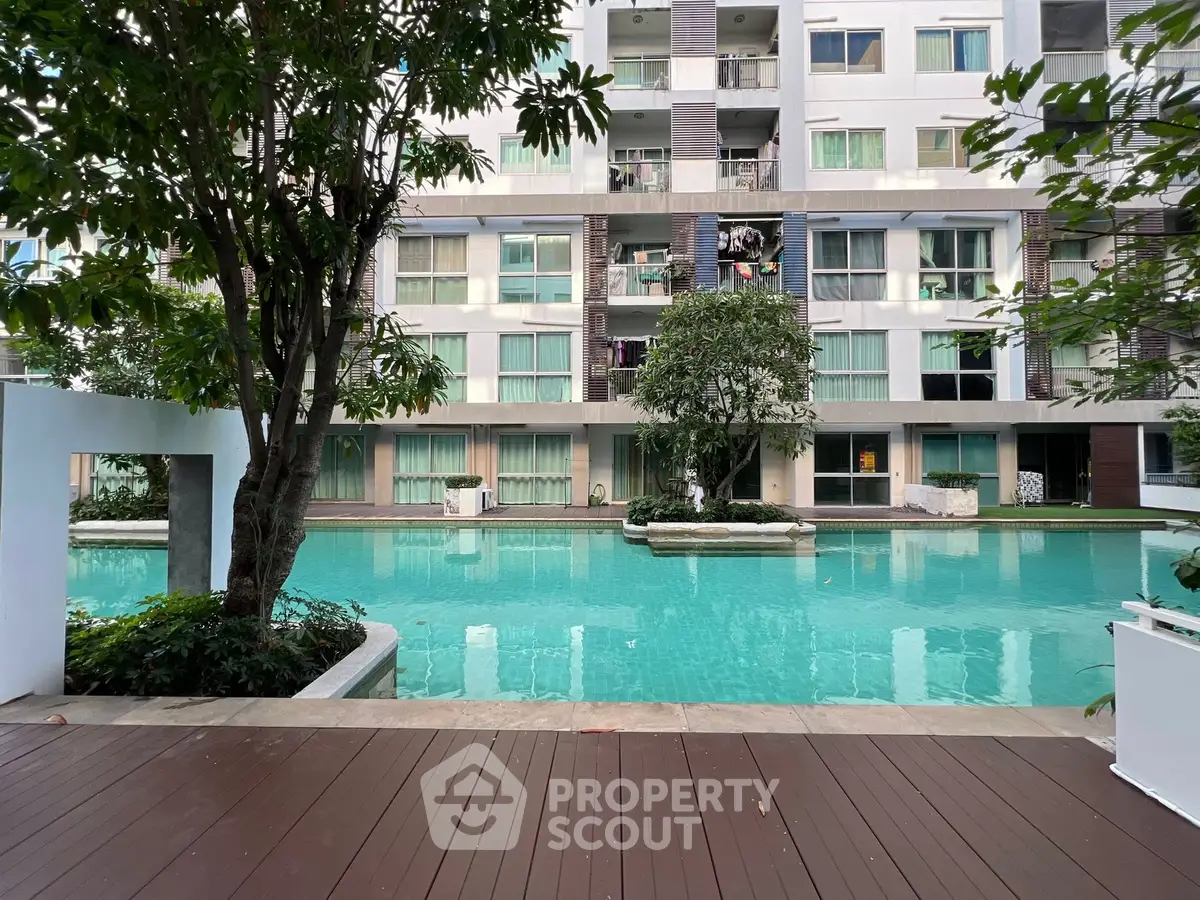 Luxurious apartment complex with serene pool view and modern architecture.