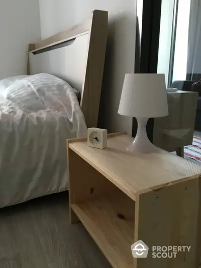 Cozy bedroom with modern wooden bed and stylish lamp on bedside table.