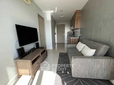 Modern living room with sleek furniture and wall-mounted TV in a cozy apartment.