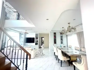 Luxurious open-plan living and dining area with elegant chandeliers and modern decor.