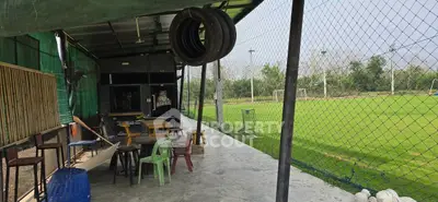 Charming outdoor seating area overlooking lush green soccer field, perfect for sports enthusiasts.