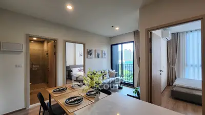 Modern open-plan apartment with dining area, living room, and bedroom, featuring stylish decor and city view.