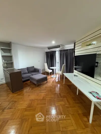 Spacious living room with modern furniture and parquet flooring, perfect for relaxation and entertainment.