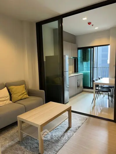 Modern open-plan living room and kitchen with sleek design and natural light.